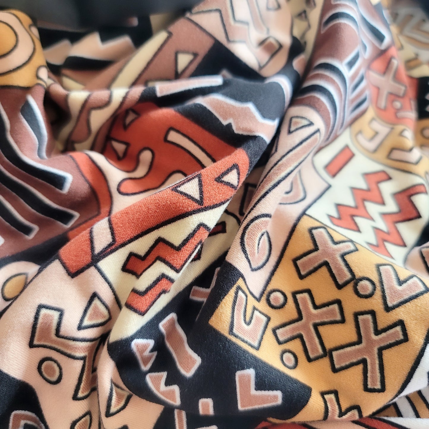 A vibrant close-up of a colorful oversized throw featuring intricate geometric patterns.