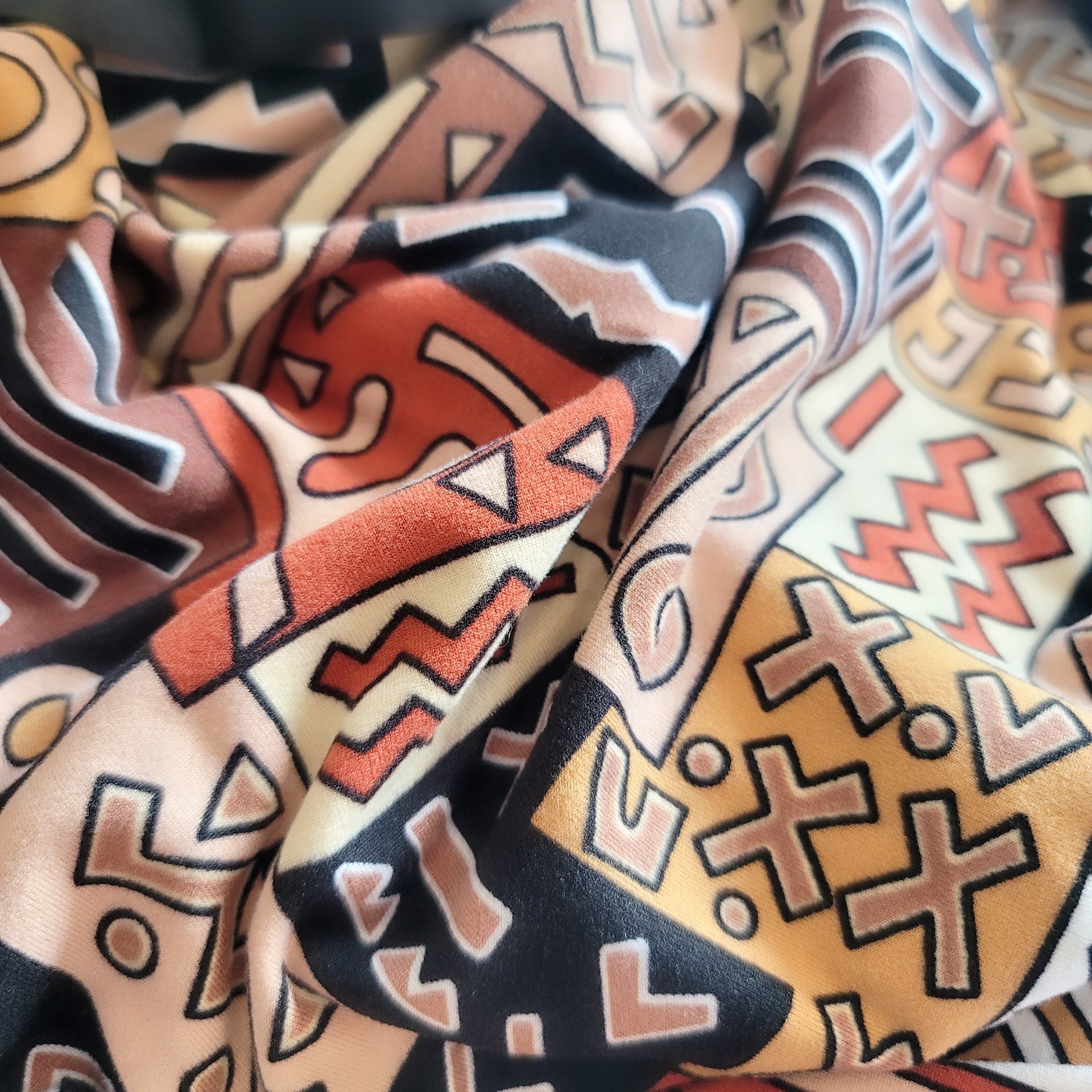 A vibrant close-up of a colorful oversized throw featuring intricate geometric patterns.