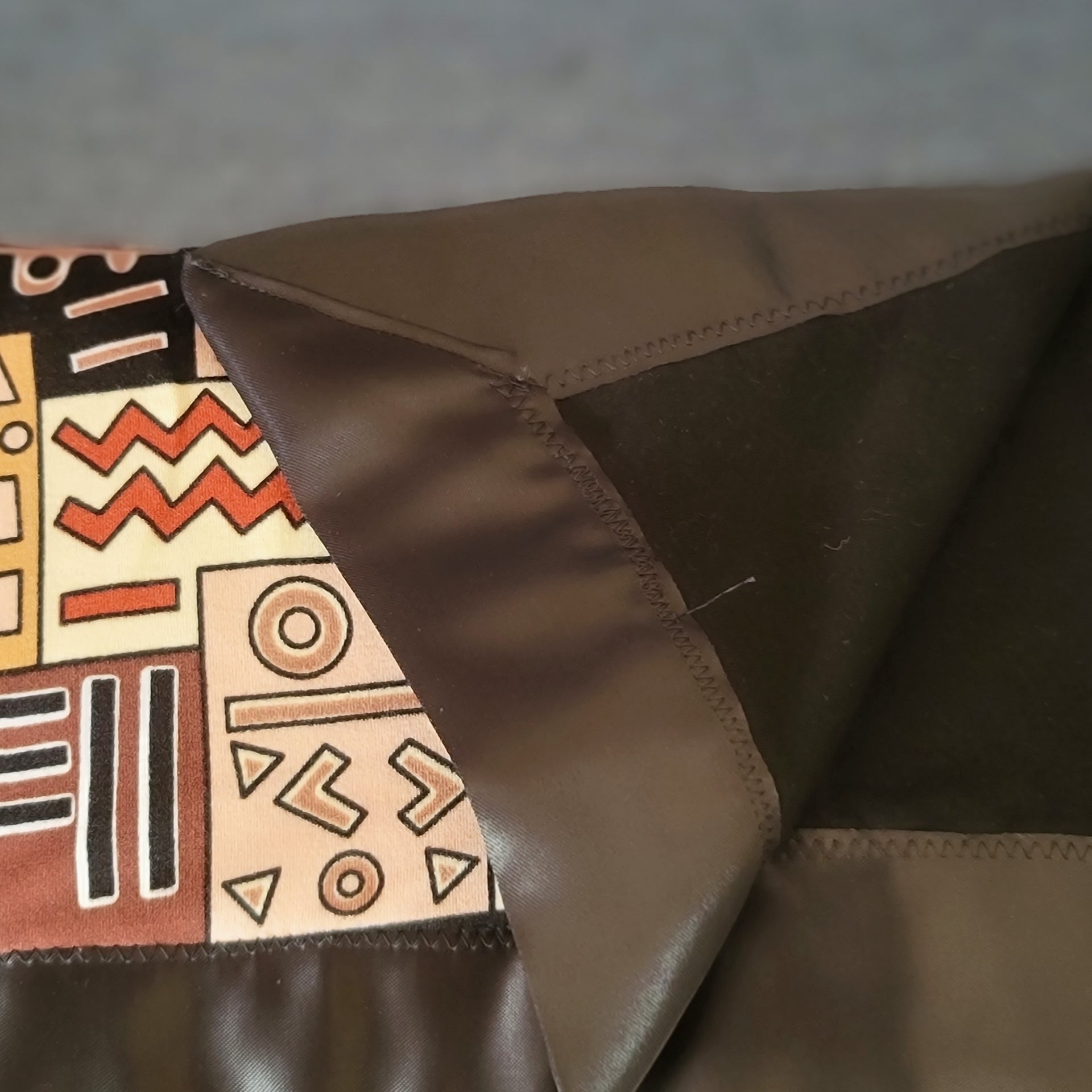 A vibrant close-up of a colorful oversized throw featuring intricate geometric patterns.