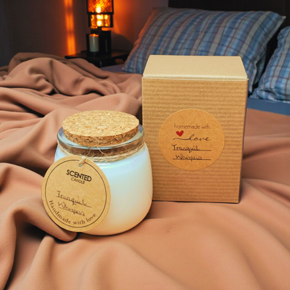 Scented candle with cork lid and packaging on a bed
