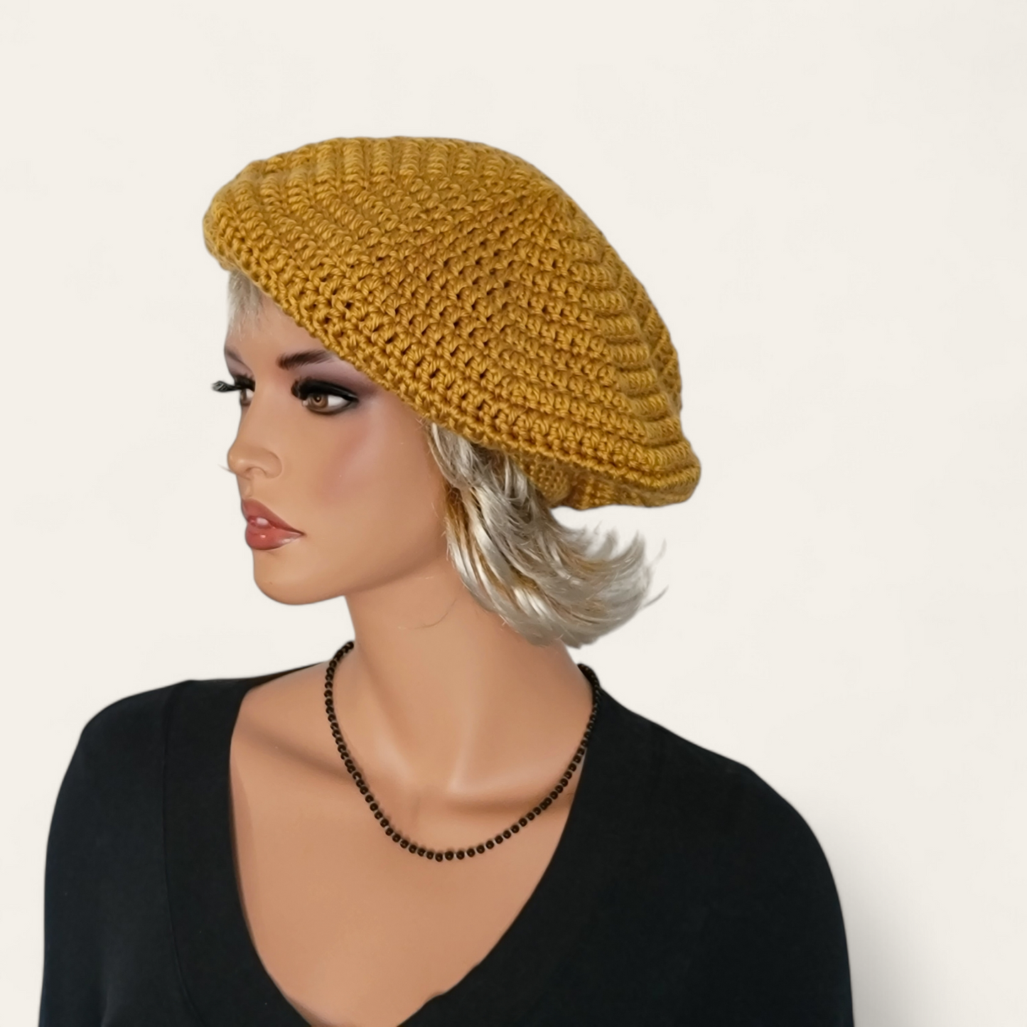 Gold crocheted beret without pom-pom on mannequin