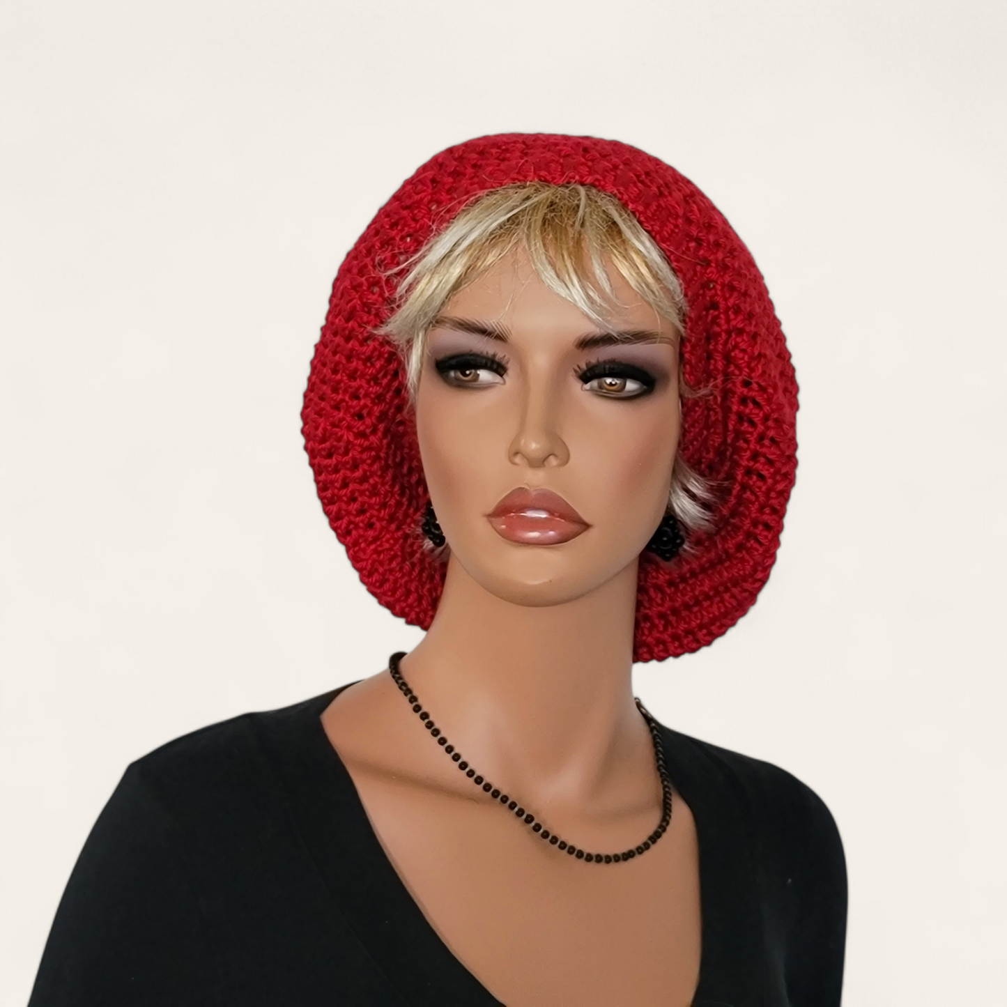 Red crocheted beret without pom-pom on mannequin