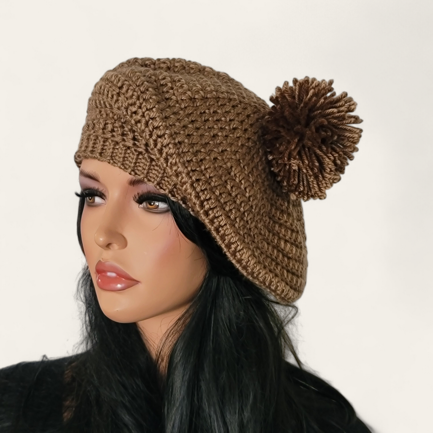 Walnut brown crocheted beret with pom-pom on mannequin.