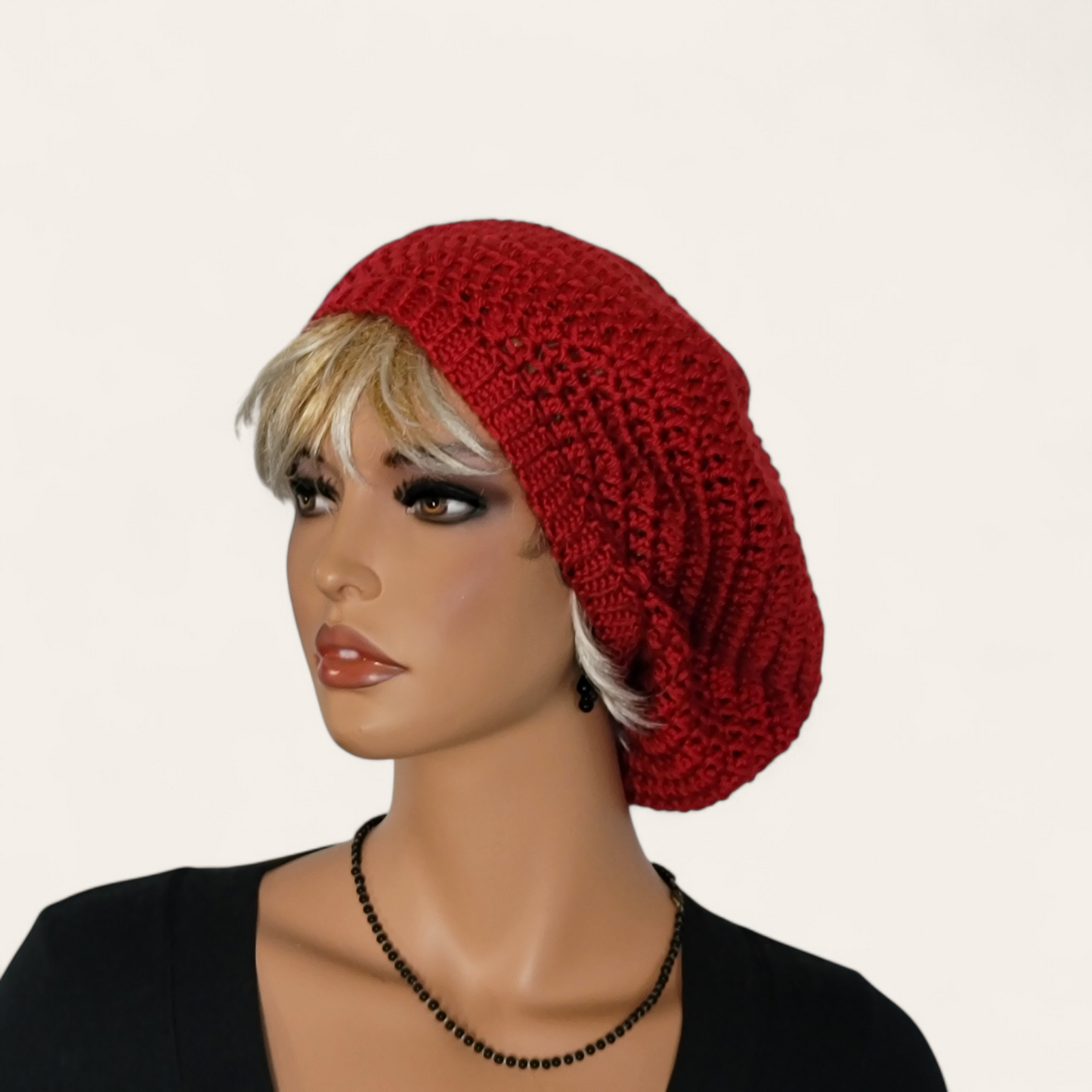 Red crocheted beret without pom-pom on mannequin