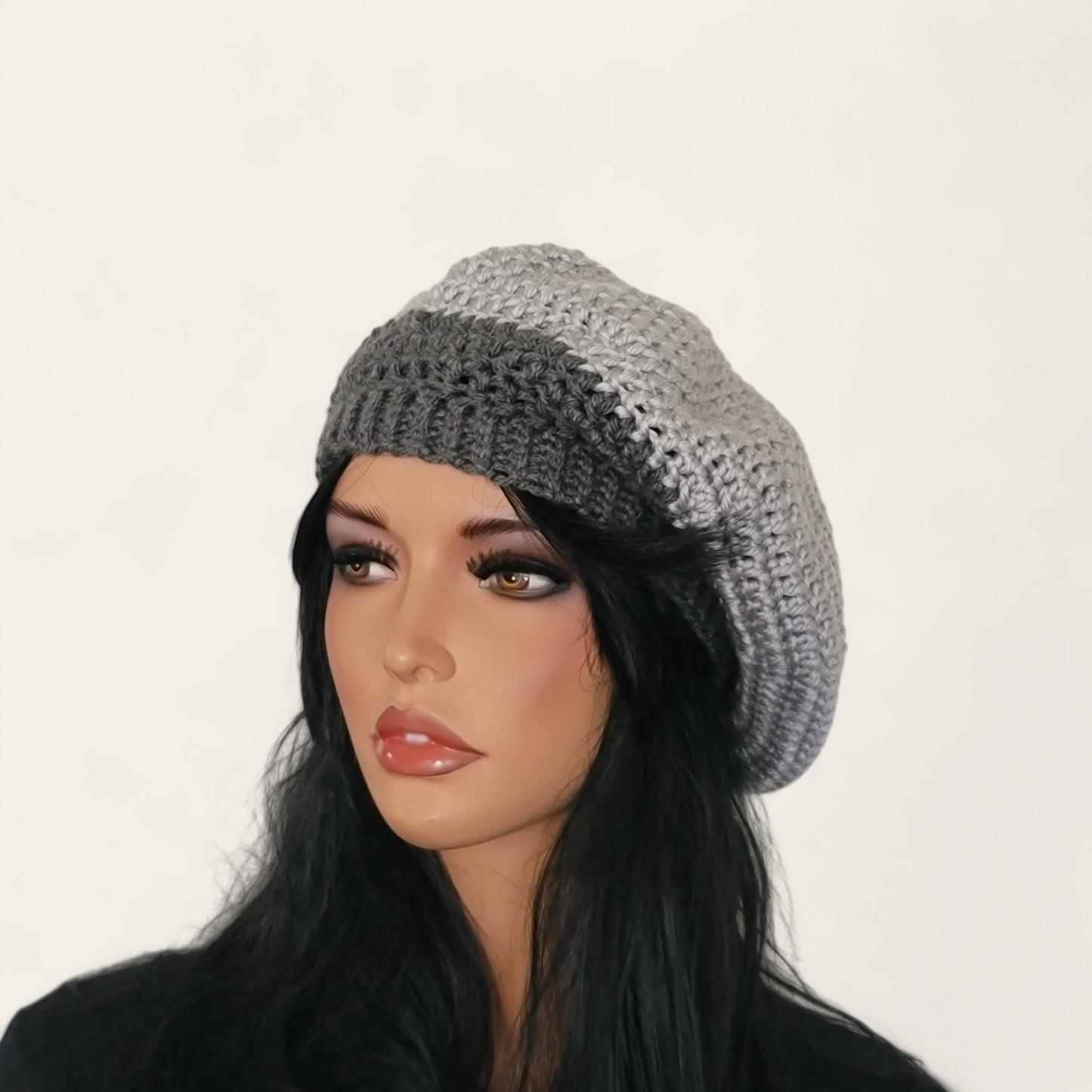 Two-toned grey crocheted beret without pom-pom on mannequin.