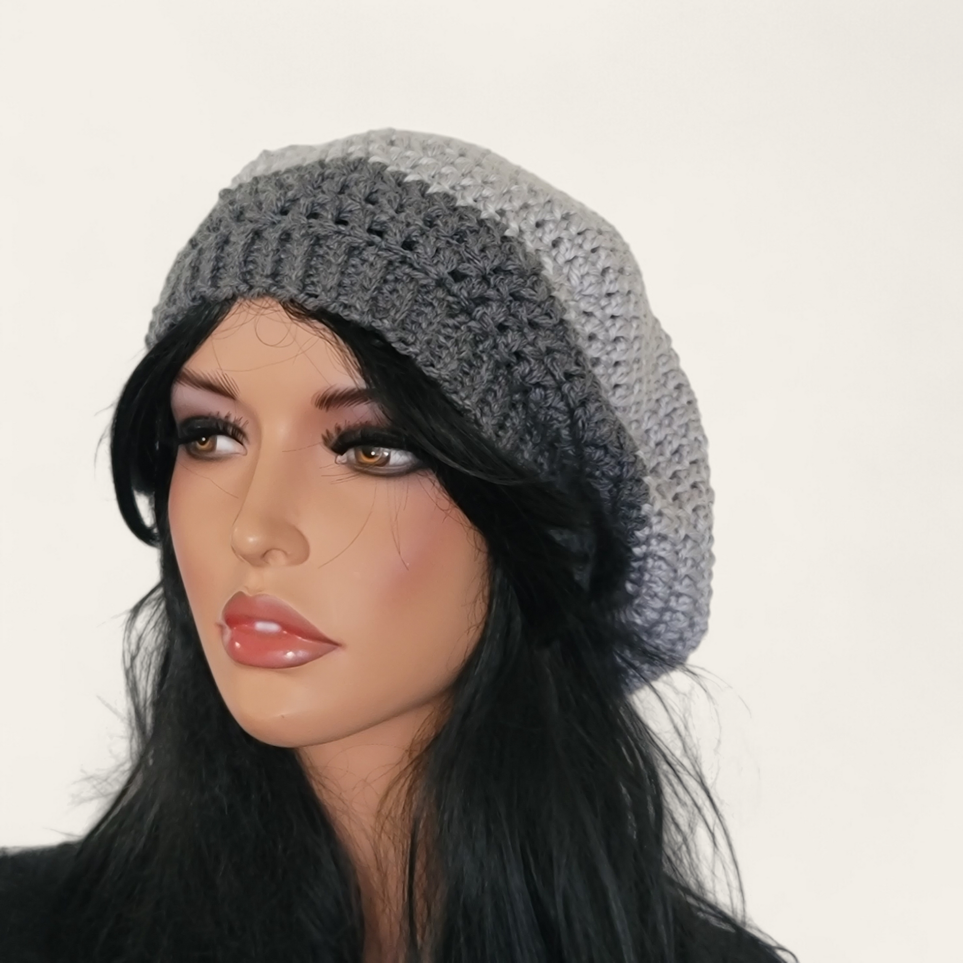 Two-toned grey crocheted beret without pom-pom on mannequin.