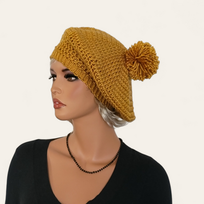 Gold crocheted beret with pom-pom on mannequin