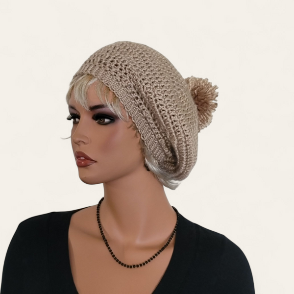 Tan crocheted beret with pom-pom on mannequin.