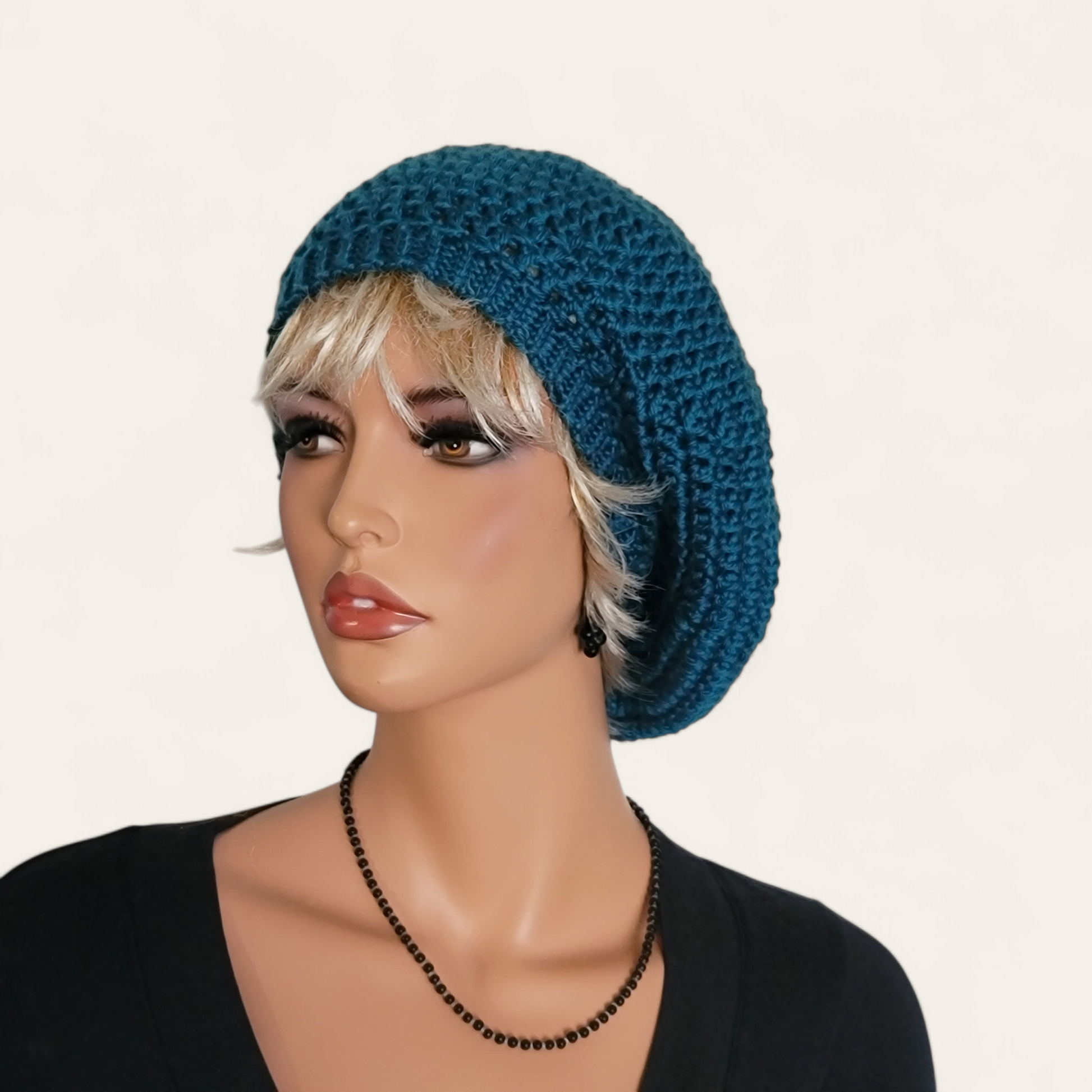 Teal crocheted beret without pom-pom on mannequin