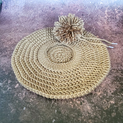 Walnut brown crocheted beret with pom-pom on side, flat lay.